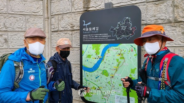 서울 둘레길 3코스 두 번째 구간 푯말 앞에서 이동희 팀장이 오늘 산행하는 코스에 대해 설명을 듣고 사진을 찍다.(좌: 윤근일 부단장, 이동희 팀장, 이종화 단장)