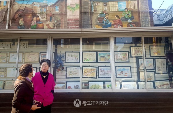 ▲세지로 담벼락 미술관에서 지역 주민들의 작품을 보며 이야기를 나누고 있는 김낭자 시민기자(왼쪽)와 신현옥 회장(오른쪽)의 모습 