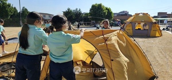 대원들이 협력하여 텐트치기를 하고 있다