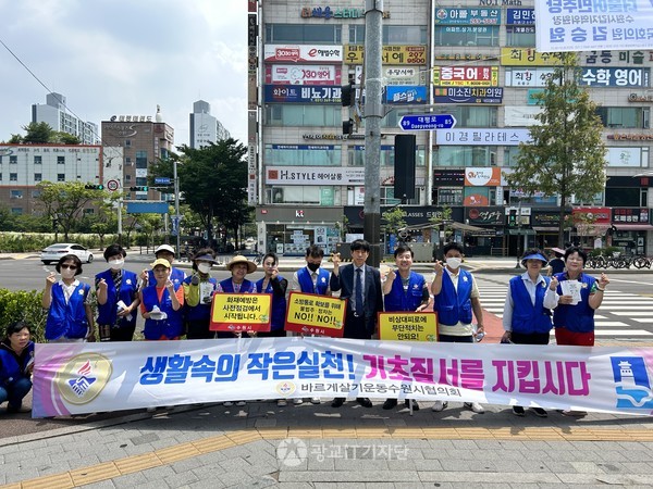 팔달구 위원들이 정자동 상가 주변에서 기초 질서 캠페인 후 기념 촬영을 했다