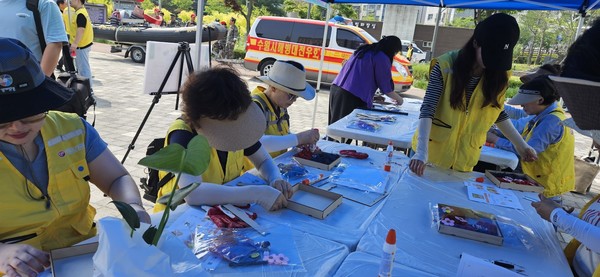 탄소중립 실천체험부스에서 스킨다이모스 액자를 만들고 있는 자원봉사자들