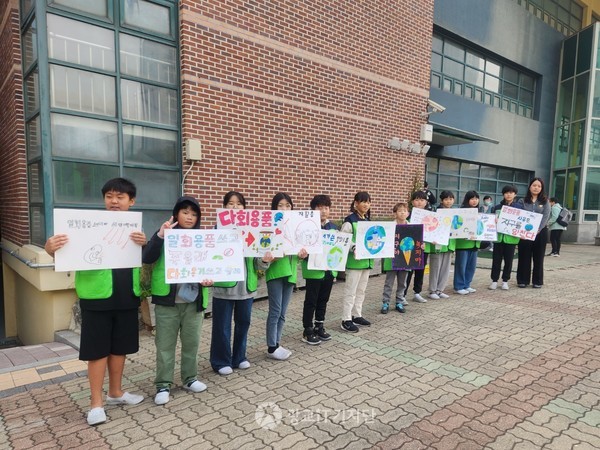 전교학생자치회 임원들이 등굣길에서 환경보호 문구가 적힌 피켓을 들고 일회용품 줄이기 캠페인을 벌이고 있다.